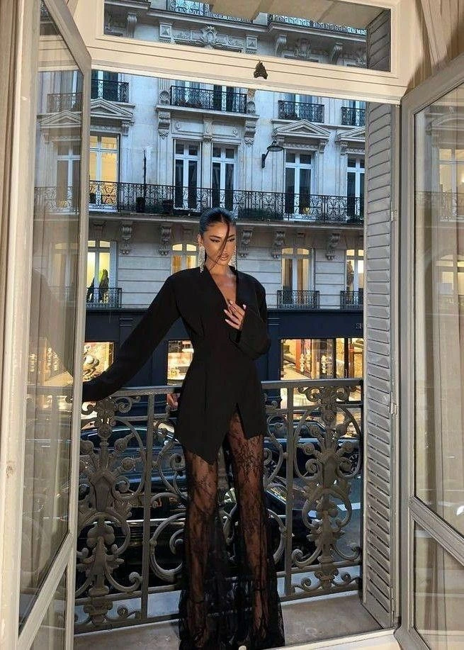Woman in dramatic black evening look on Parisian balcony