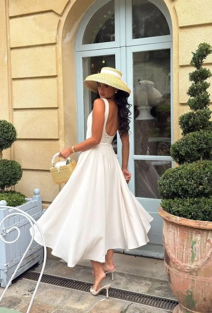 Woman in flowing white dress with straw hat
